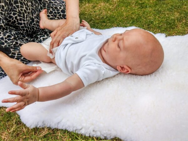 sheepskin being used as a changing mat in the park